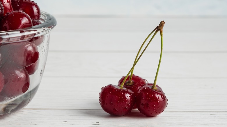 three cherries on counter and cherries in bowl