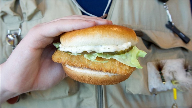 person holding panko fish sandwich