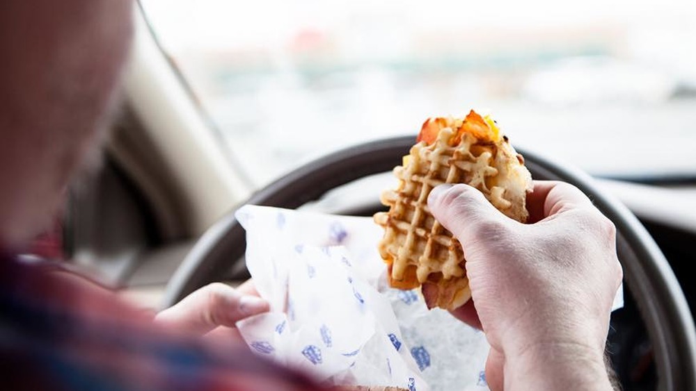 Man holding White Castle waffle sandwich 