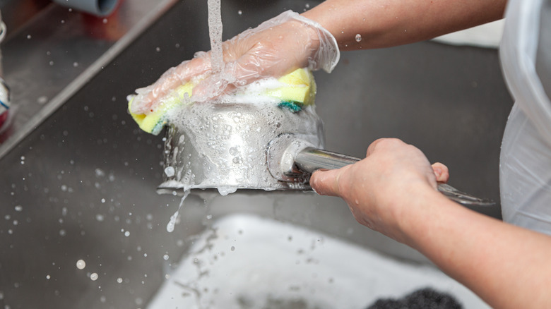 Close up of washing a pan under running water