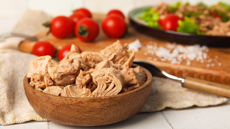 tuna in wooden bowl and tomatoes