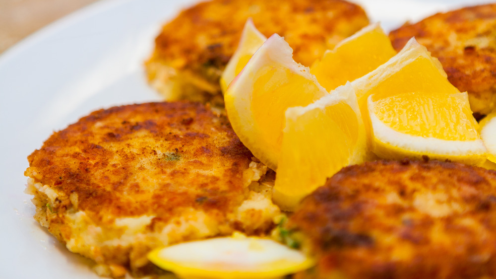 plate of crab cakes with lemon wedges