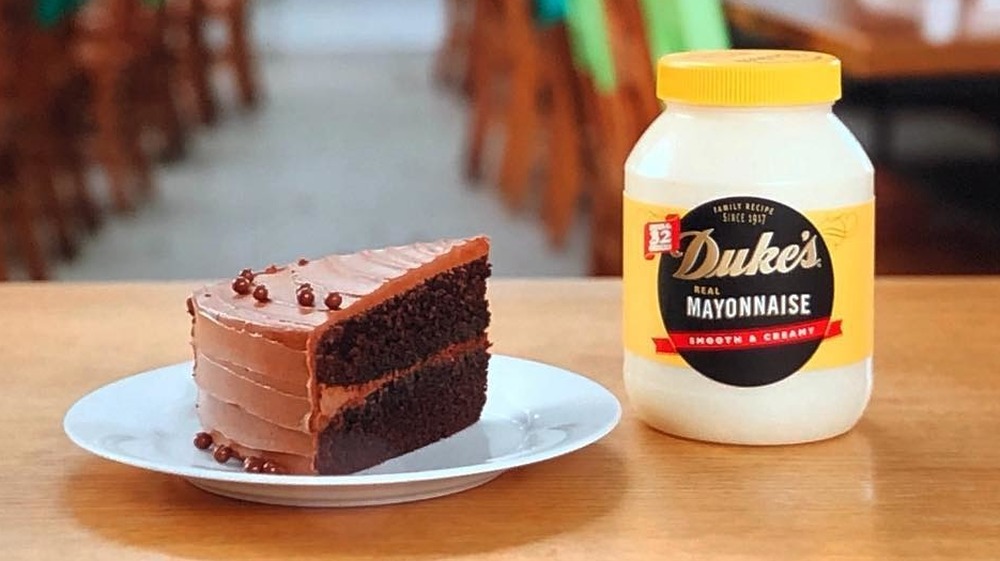 slice of chocolate cake on a plate next to a tub of Duke's Mayonnaise