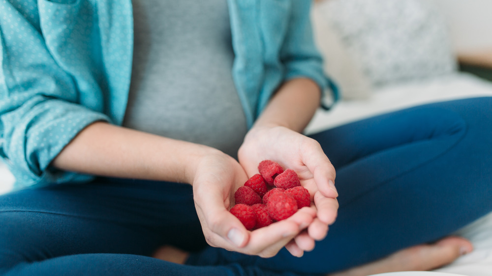 Hands holding raspberries