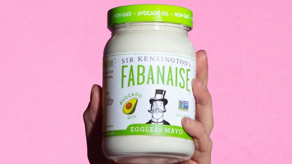 Hand holding jar of Sir Kensington's eggless mayo