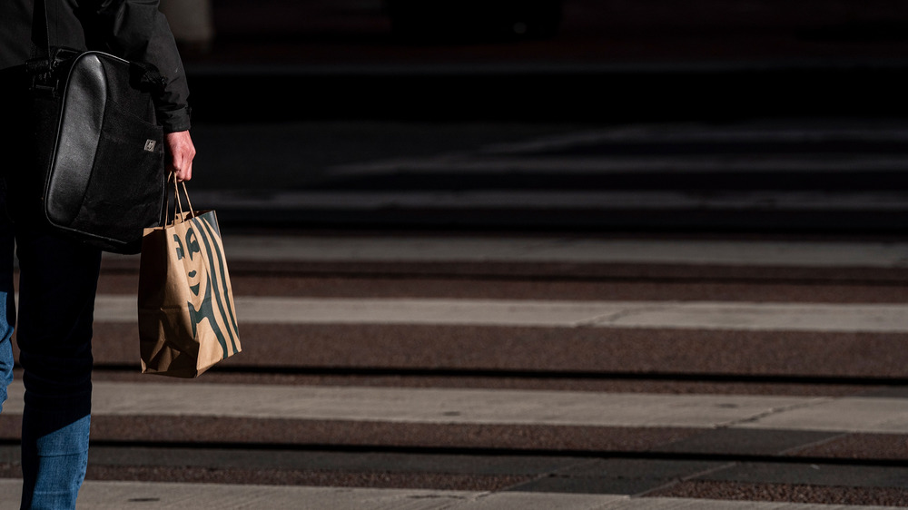 Person holding Starbucks bag