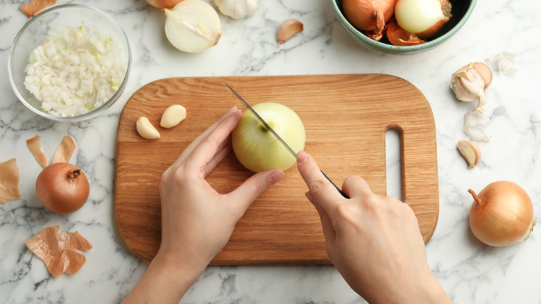 cutting white onions wooden board