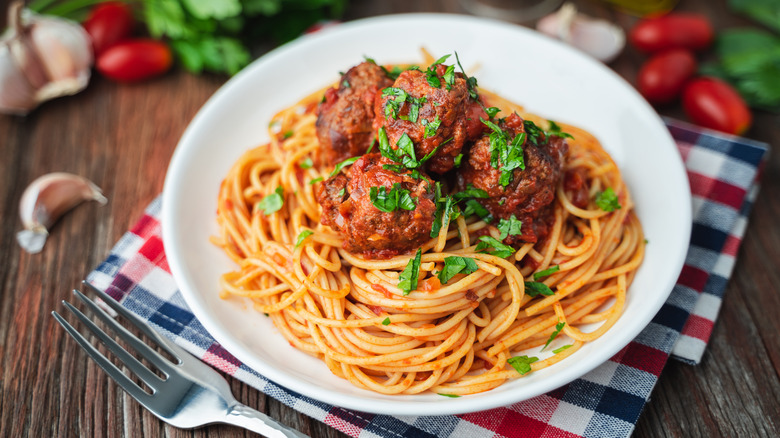 Spaghetti and meatballs on checkered cloth