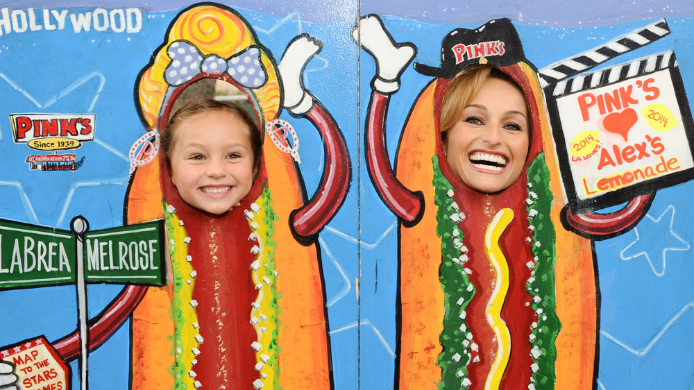 Giada De Laurentiis and Jade Thompson behind a hot dog cutout