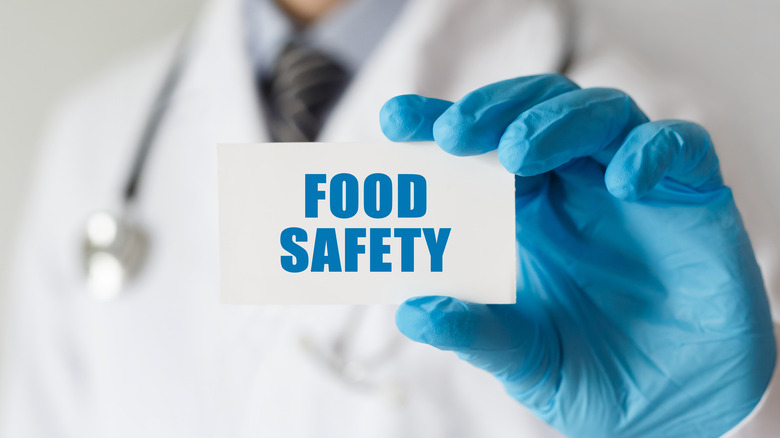 Doctor holding up a "food safety" sign