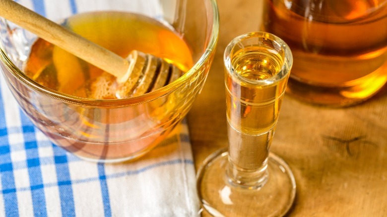 mead drink in glass next to bowl of honey
