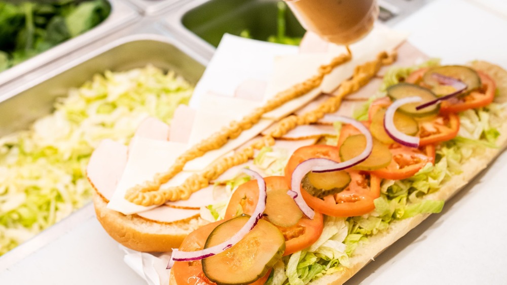 Subway worker preparing footlong sub