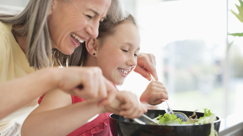 Lady and girl tossing salad