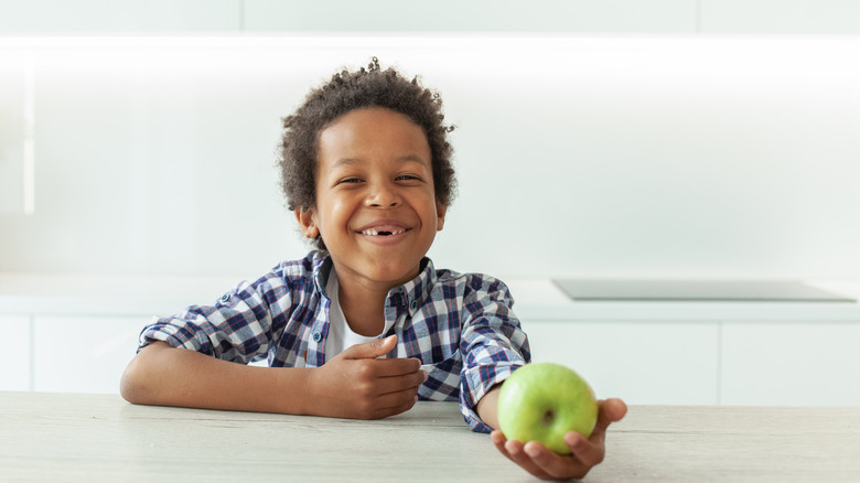 Child with apple smiling