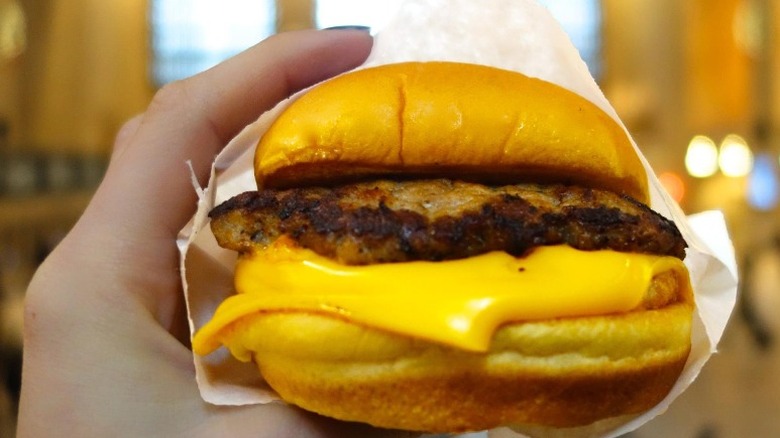 Hand holding Shake Shack burger