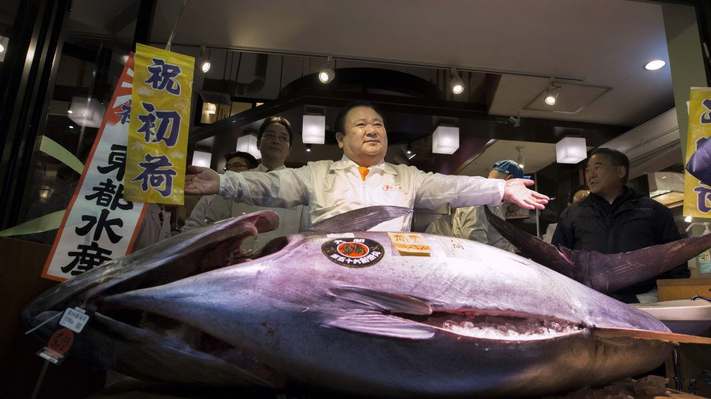 man poses with a massive tuna