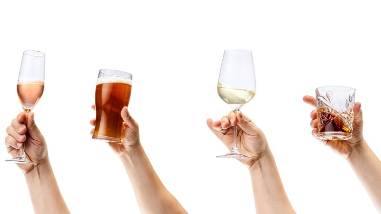 several hands holding different glasses of alcohol