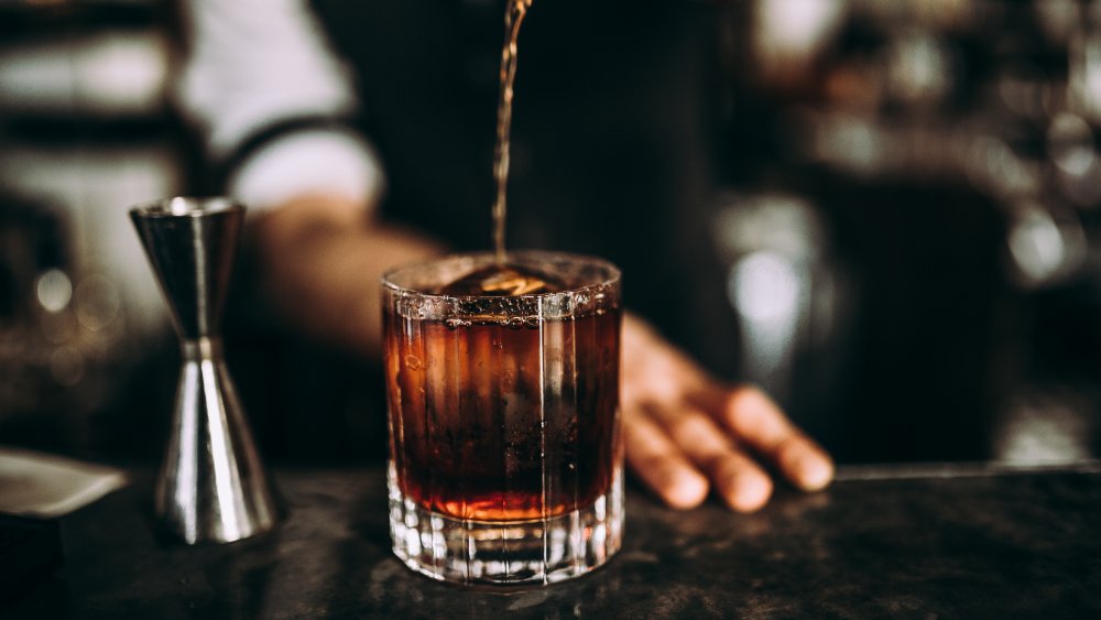 Pouring a bourbon cocktail