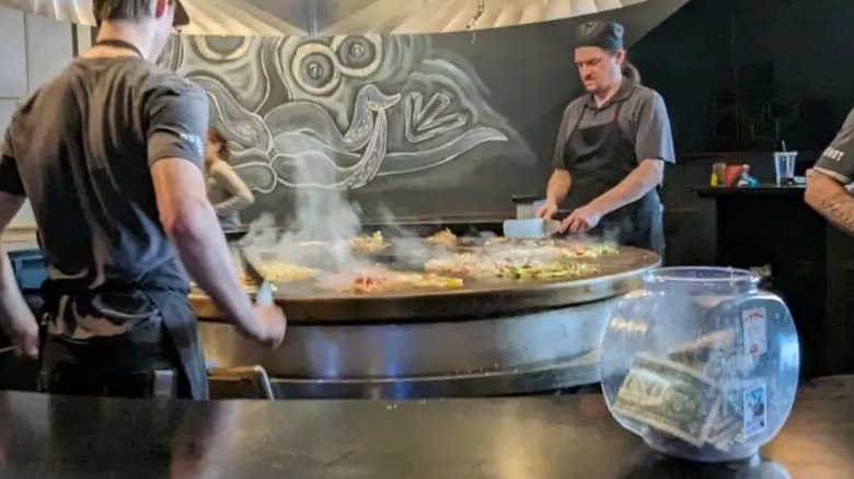 Mongolian BBQ chefs grilling with tip jar