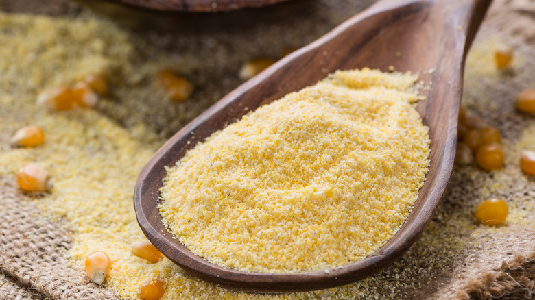 Cornmeal scooped with wooden spoon