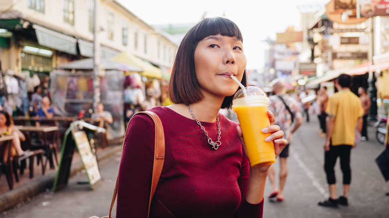 Woman drinking orange smoothie