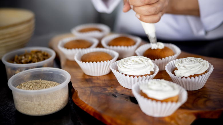 Person decorating cupcakes