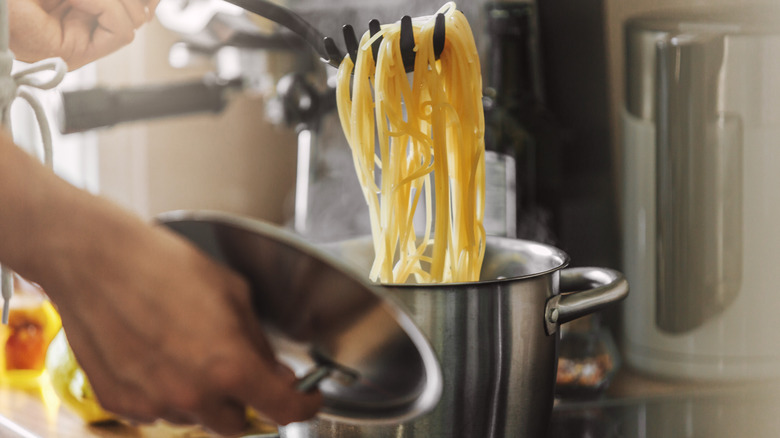 Noodles being taken out of pot