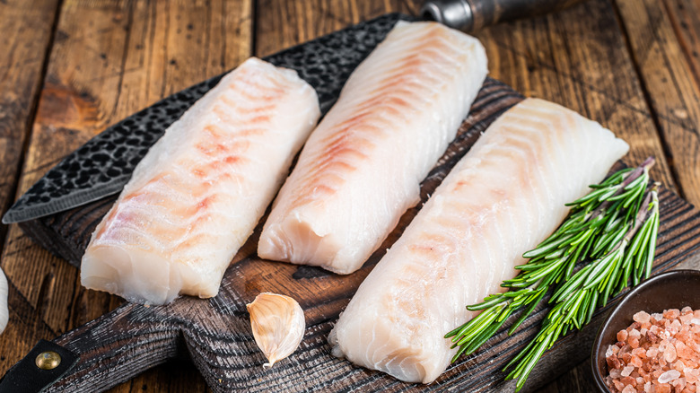 Raw cod filets on black board