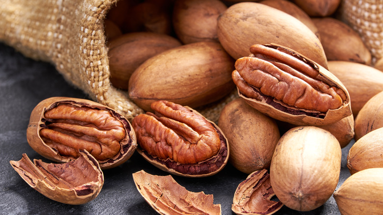 Pecans and shells pouring out of burlap sack