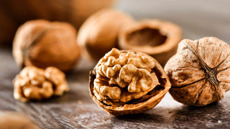 Walnuts and shells on wooden surface