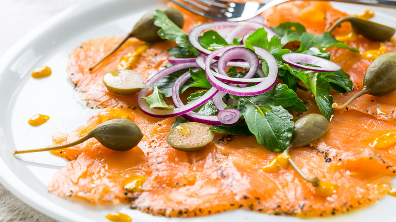 Salmon carpaccio with capers arugula and red onion