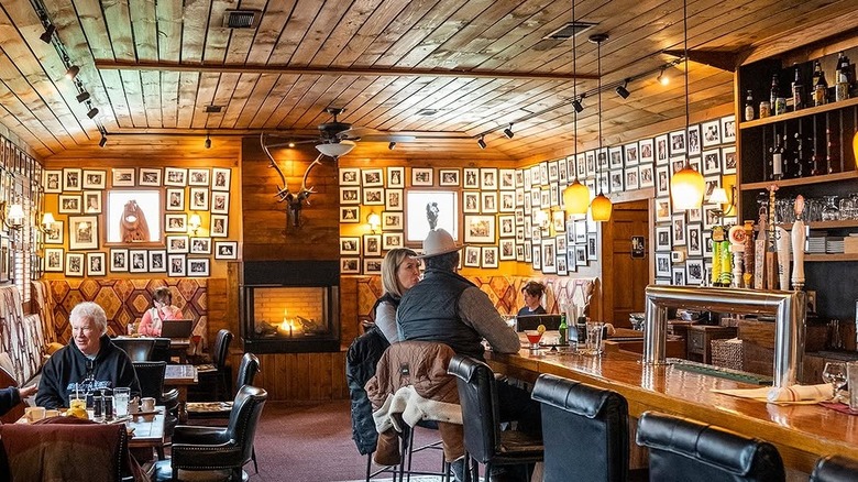 Antlers Bar with customers and pet portraits in the background on the walls