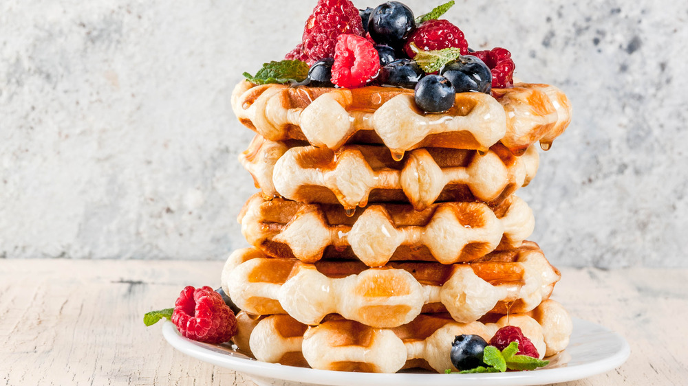 Belgian waffle stack topped with berries and syrup