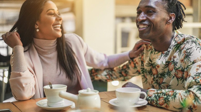 man and woman laughing in cafe