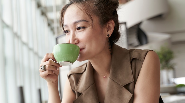 East Asian woman sipping tea