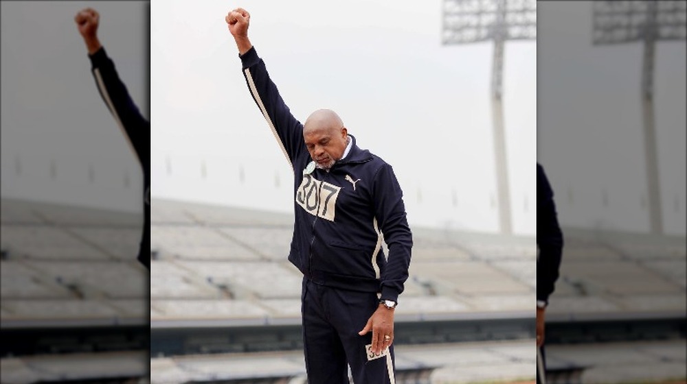 Older Tommie Smith raises his fist