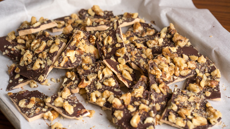 Toffee pieces on a paper-lined baking sheet