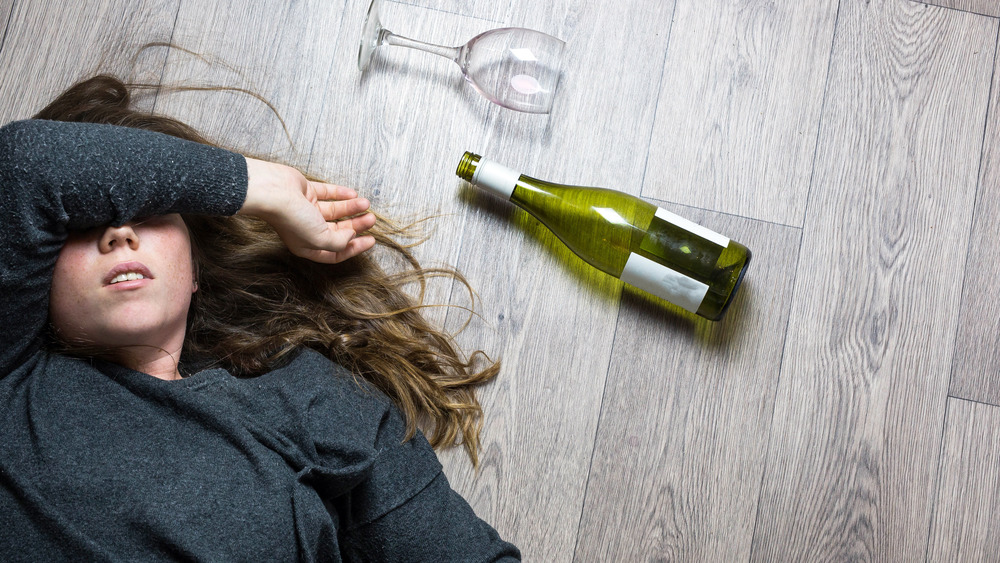 Woman lying with wine bottle