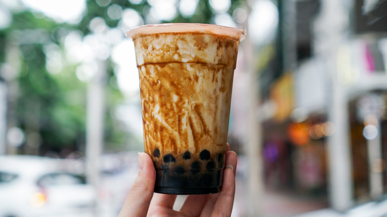 A hand holding a brown sugar bubble tea