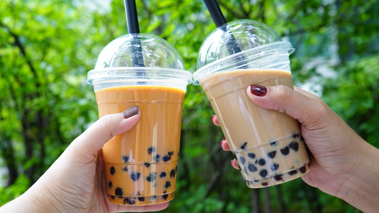 Two women holding two bubble teas