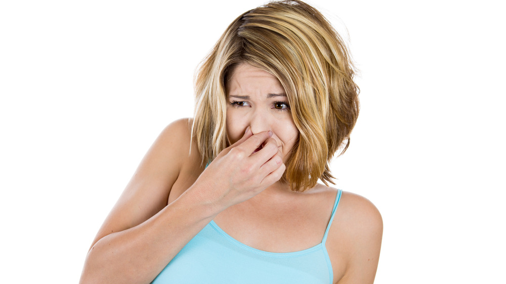 woman holding her nose bad smell