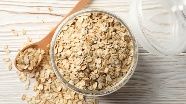 bowl of raw oats with wooden spoon