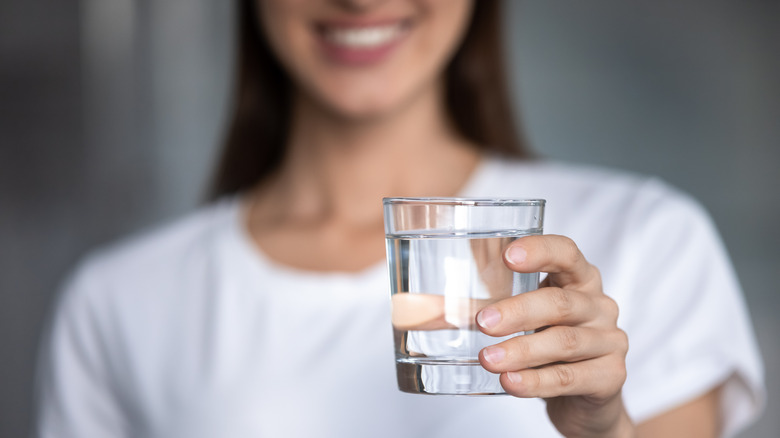 Person smiling while drinking water