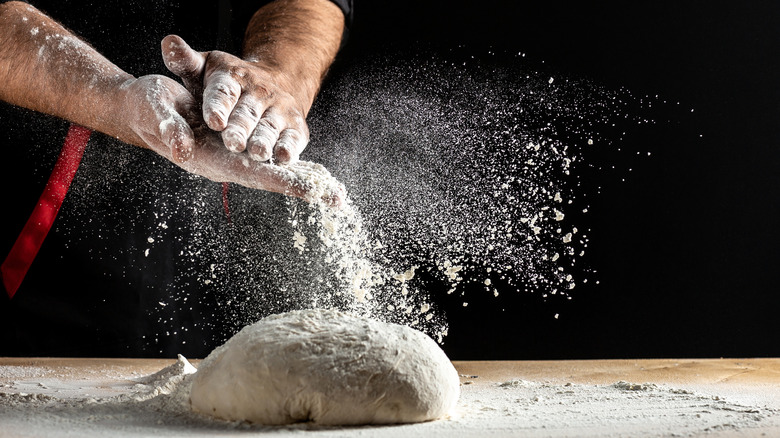 hands flouring bread dough