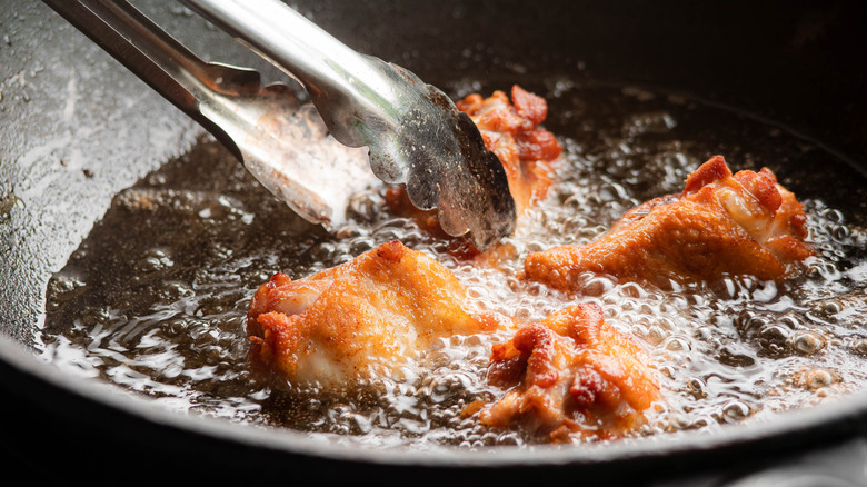 chicken frying in pan