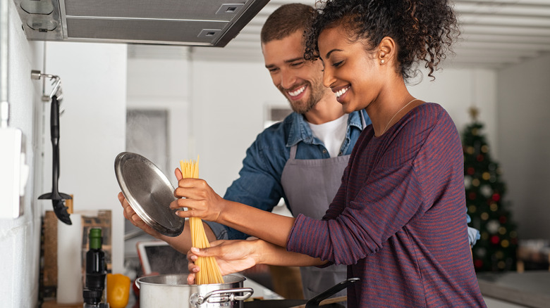 happy couple boiling spaghetti