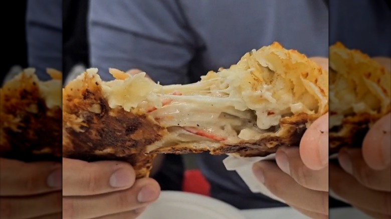 Person pulling apart Costco Seafood Bake