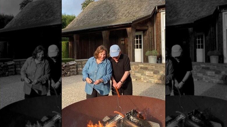 Ina Garten and Jeffrey grilling hot dogs outside