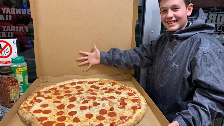 boy opening large pizza box