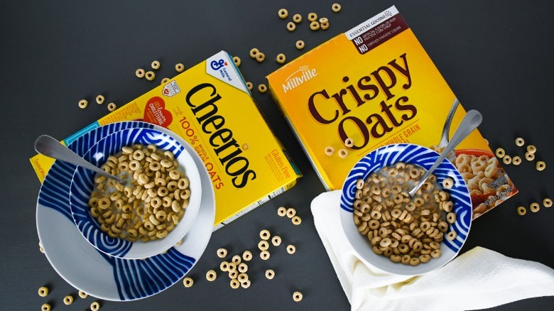 boxes of cheerios and crispy oats cereal with bowls of cereal